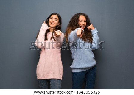 Teenager friends making phone gesture and pointing front
