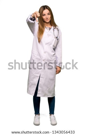 Full body Young doctor woman showing thumb down sign with negative expression on isolated background