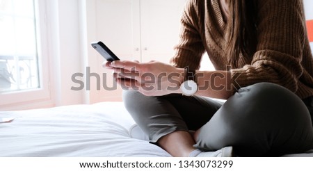 Woman is holding her mobile phone in hand
