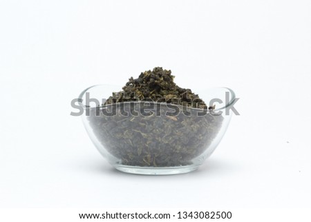 Tea loose in a transparent container on a white background.