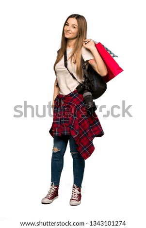 Full body Young photographer woman holding a lot of shopping bags on isolated background