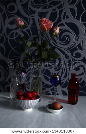 Still life with radish and egg in white and blue pots, colorful bottles, vases with flowers  