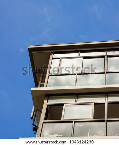 Bottom view of apartment building flats with blue sky in background photo of windows