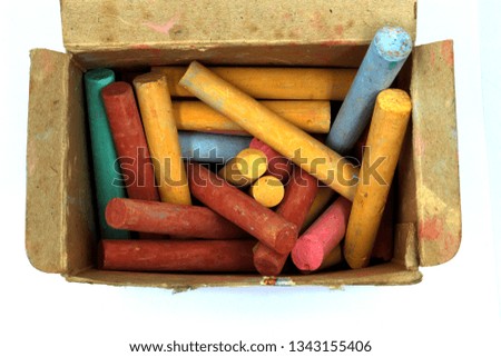 color chalks stick in old paper box isolated on white background 
