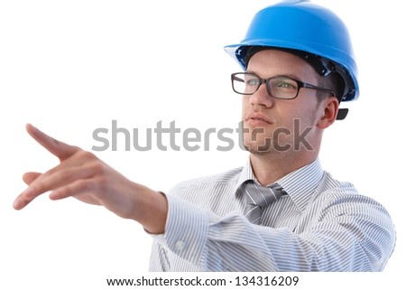 Engineer working at construction site, wearing hardhat.