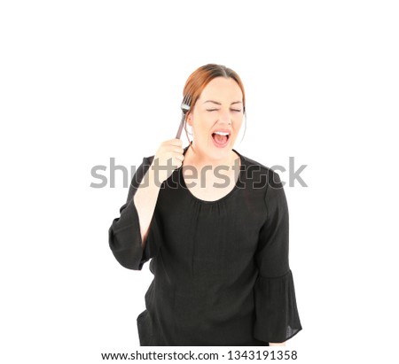 Confident young woman smiling and holding a fork while winking against a white background