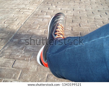 fashionable men's sneakers and jeans with orange laces