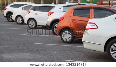Image of cars parking in outdoor parking lot with natural background in twilight evening of sunny day. The mean of transportation in modern world. Royalty-Free Stock Photo #1343214917