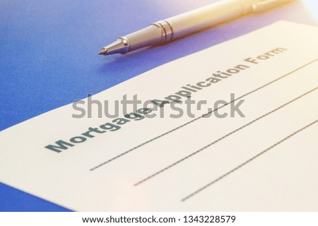 Mortgage application form with pen on the blue background.