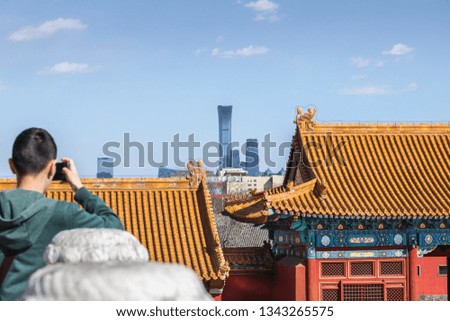 A Tourist Taking Picture at Forbidden City. Old traditional and Modern buildings in Beijing, China