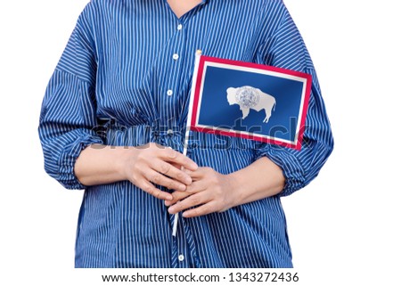 Wyoming state flag. Close up of woman's hands holding flag of Wyoming isolated on white background.