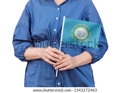 South Dakota state flag. Close up of woman's hands holding flag of South Dakota  isolated on white background.