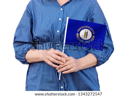 Kentucky state flag. Close up of woman's hands holding flag of Kentucky isolated on white background.
