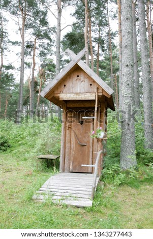 Wooden ecological composting toilet on countryside with a heart shape in the door