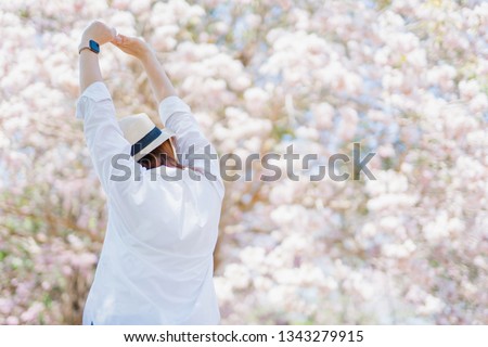 spring season with full bloom pink flower travel concept from beauty asian woman enjoy and relax with sight seeing sakura or cherry blossom with soft focus flower background