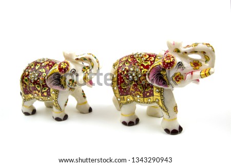 Marble beautiful white elephant statuette with red and gold painted rhinestones, isolated on a white background, a traditional Indian souvenir, Idea design concept with copy space add text. Objects.