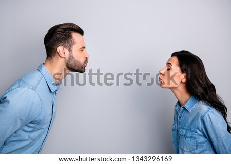 Blind dating. Profile side photo close up of cute funny shy spouses sending air kisses closing eyes showing affection feelings dressed in fashionable blue jackets isolated on ashy-gray background Royalty-Free Stock Photo #1343296169