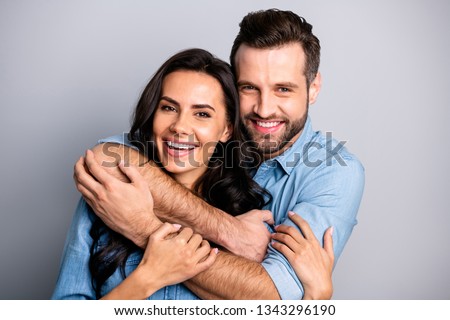 Close up photo of handsome casual joyful cute spouses  cuddling bonding placing arms around neck sharing rejoice dressed in blue denim clothing isolated on argent background Royalty-Free Stock Photo #1343296190