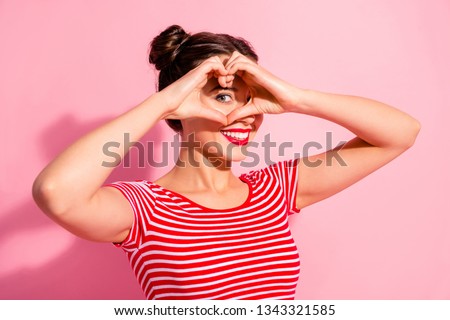 Close up photo beautiful she her lady pretty two buns pomade lips hold hands arms heart shape figure near eye hide face cardiac health wear casual striped red white t-shirt isolated pink background