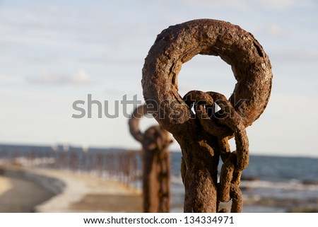 Rusty old post, bollard and chain, Newcastle Beach, Australia