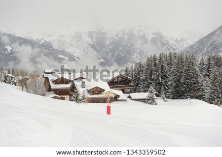 Ski resort in French alps with snow and chaltes in winter 