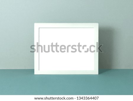 Pastel frame mockup to place your design in and sell in your shop. White 8x10 frame on soft blue background.