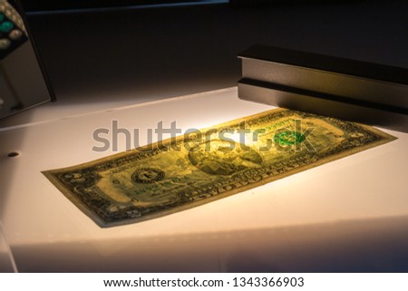 Verifying the authenticity of the two-dollar bill in penetrating light. US banknotes. Thomas Jefferson, the third President of the US. Equipment for in-depth inspection of money. Fake money concept