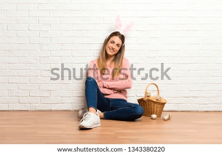 Young woman wearing bunny ears for Easter holidays keeping arms crossed