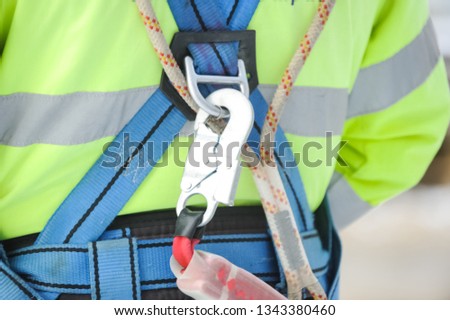 The hook of the safety carabiner attached to the safety belt is worn on the worker.