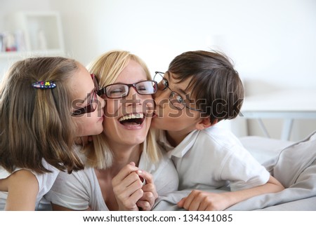 Portrait of children kissing her mom