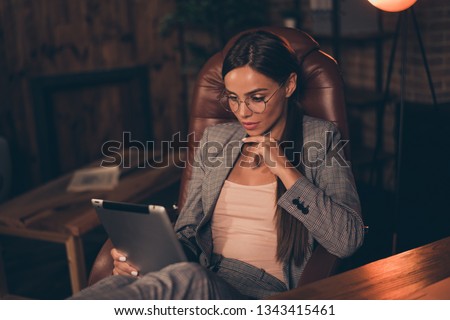 Close up side profile photo she her business lady chief hand chin e-reader e-book reading report information learn study compare analyze sit office chair wear specs formal wear checkered suit