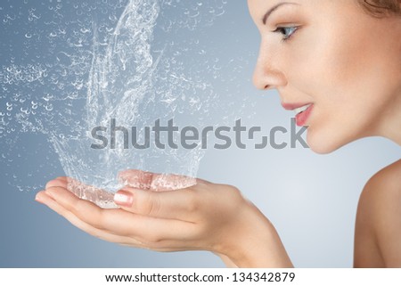 Young woman washing her face and hands with clean water in the morning Royalty-Free Stock Photo #134342879