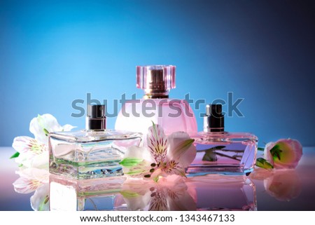 bright colored bottles of female perfume on a blue background