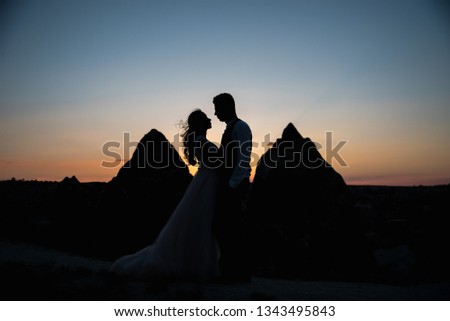 Silhouette couple in love and mountains in the light of sunset