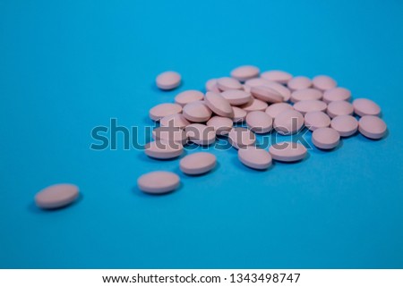 pink oval pills vitamins for pregnant women on blue background