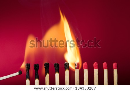 Burning match setting fire to its neighbors, a metaphor for ideas and inspiration Royalty-Free Stock Photo #134350289