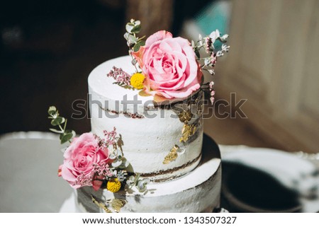three-tier wedding cake. white cake decorated with fresh flowers. luxury wedding dessert.