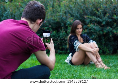 Man taking picture of women with smart phone