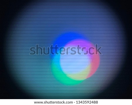 A blurry macro view of a colorful LED light up close showing red, green, and blue LED's overlap to form white.