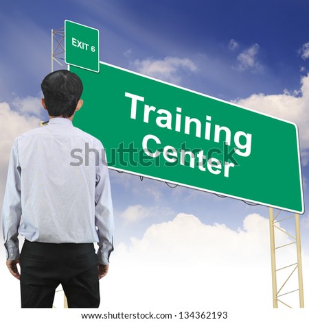 Businessman standing in front Road sign concept with the text Training Center