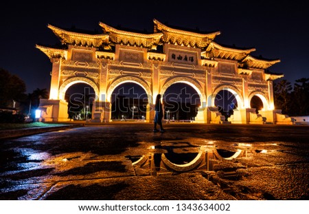 Golden Liberty Square Arch of Taipei Taiwan at night. A tourist admires the vibrant main gait to Liberty Square of Taipei

Translation:  Free Square