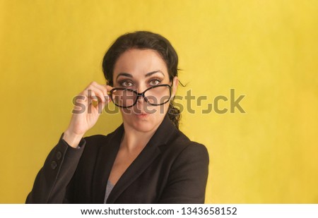 Wow. Beautiful young business woman, with pigtail, glasses and black jacket, isolated on a background. Surprised, stunned. Positive human emotion