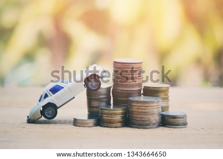 close up stack of coin and yoy car on old wood table, saving money for future, manage to success transport business technology concept