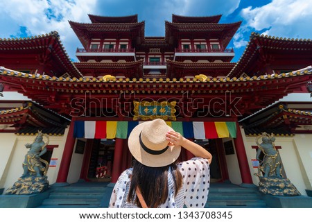 Woman toursit is traveling at Buddha relic temple with Singapore urban city skyline with beautiful landmark and iconic view. (Chinese means Buddha relic temple) Royalty-Free Stock Photo #1343708345