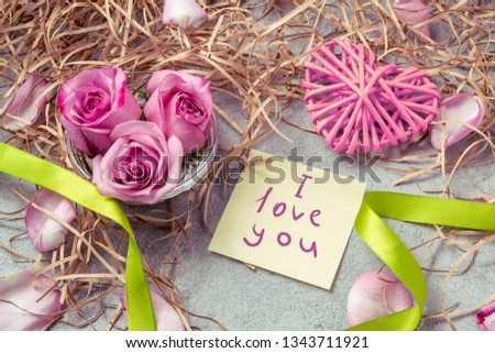 pink roses, a heart and a note with the inscription I love you on the table-the concept of love and care