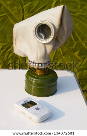 gas mask and a dosimeter on a white table