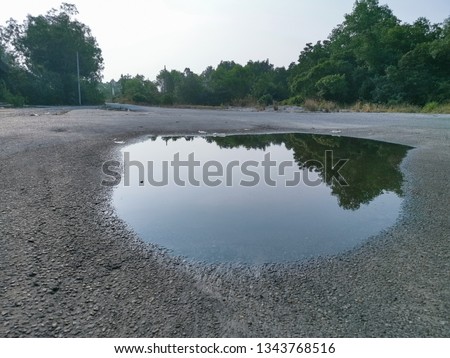 puddle middle of the asphalt road Royalty-Free Stock Photo #1343768516
