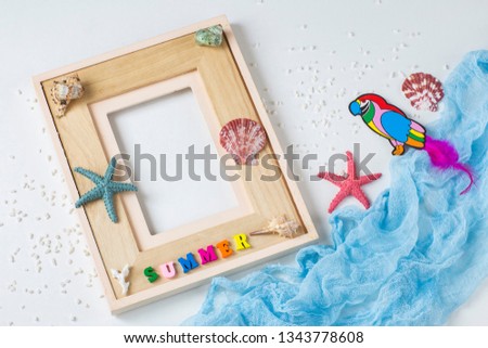 on white background photo frame, starfish, shells, the word summer, sand and a parrot. Background about summer vacation, memories