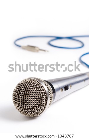 A recording studio microphone with its cord and plug out of focus