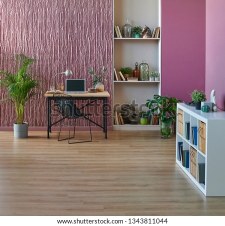 Room, wall, claret red background, decorative stone wall concept, modern book shelf and table in the room. Carpet chair vase of plant and middle table. Royalty-Free Stock Photo #1343811044